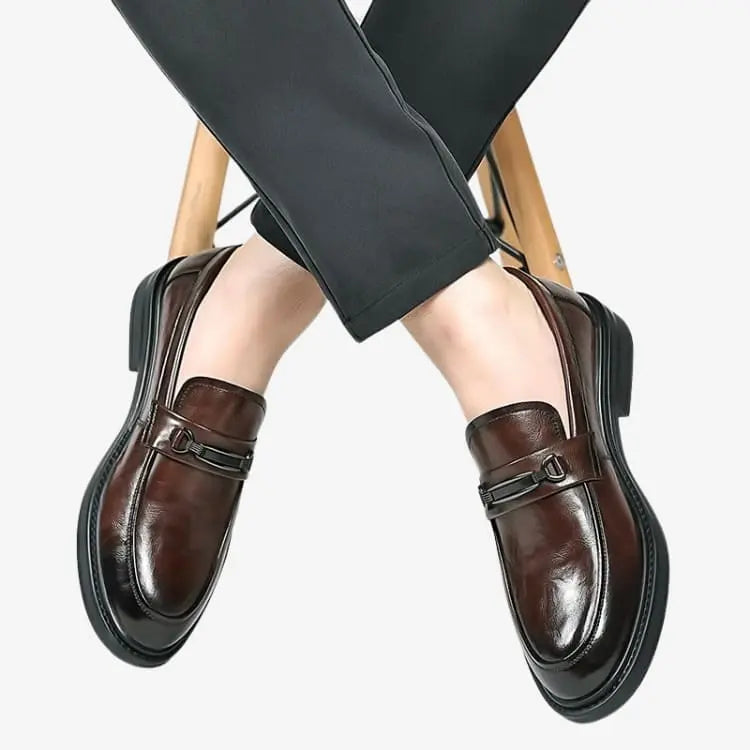 Sapato Loafer Masculino Marrom Soffisticata Bit modelo usando os sapatos sentado em uma cadeira