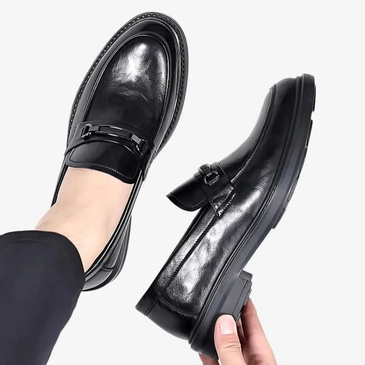 Sapato Loafer Masculino Preto Soffisticata Bit um no pé e o outro esta sendo segurado com a mão