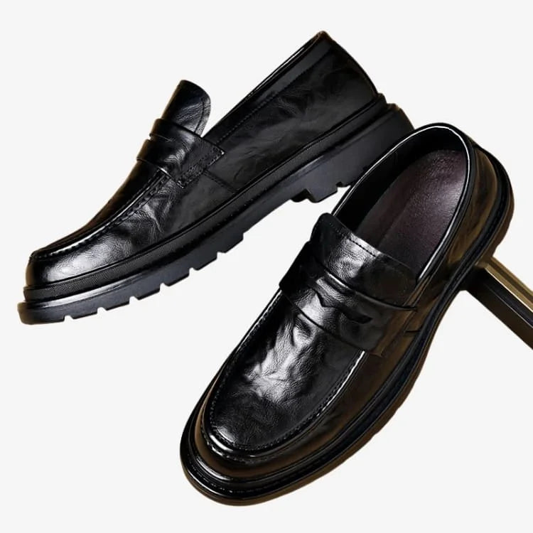 o par do Sapato Loafer Masculino Preto Soffisticata Penny Vintage encostados em um objeto metálico 